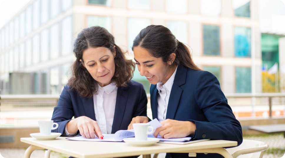 businesswomen-working-with-documents-outdoor-cafe